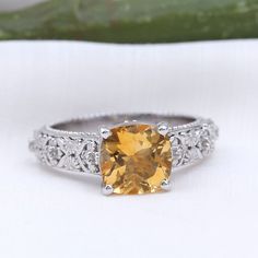 Product Details This gorgeous Cushion Cut Citrine Solitaire Ring makes for a statement accessory for women. Filigree Details are engraved on the band with Round Brilliant Diamond gemstones on the sides. This Vintage Engagement Ring is crafted in various metal options. Gift this classic ring to your mother or wife. Product Information SKU SHP-RINGS042014600 Width 6.5 mm Height 8 mm Weight 3.96 gm (Approximate) CITRINE INFORMATION No.of Stones 1 Pieces Total Weight 2.23 Carat (Approximate) Dimensi Vintage Engagement Ring, Ring With Diamond, Vintage Engagement, Classic Ring, Brilliant Diamond, Vintage Engagement Rings, Cushion Cut, Diamond Gemstone, Yellow Gold Rings