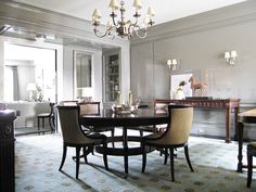 an elegant dining room with chandelier and chairs