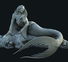 a statue of a mermaid sitting on top of a rock