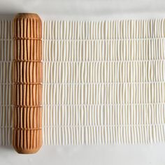 a piece of wood sitting on top of a white wall next to a wooden object