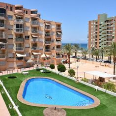 an apartment complex with a swimming pool in the foreground