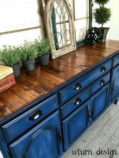 an old dresser is painted blue and has potted plants on top