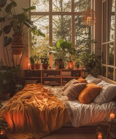 a bedroom with plants and candles on the windowsill