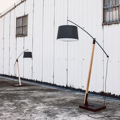 two floor lamps sitting in front of a white building