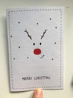 a hand holding up a christmas card with reindeer's face