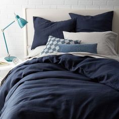 a bed with blue comforters and pillows on it