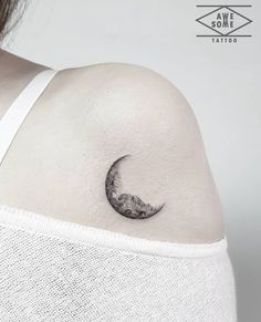 a woman's shoulder with a crescent tattoo on it