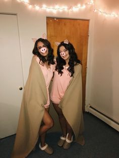 two women dressed up as pigs standing next to each other in front of a door