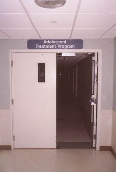 an empty hallway with a sign above the door that says adolescent treatment program on it