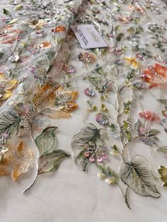 a white table cloth with flowers and leaves on it