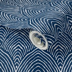 an abstract blue and white wallpaper with wavy lines on it's surface, including a roll of tape