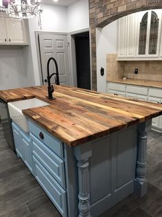 a kitchen island made out of wood and white cabinets