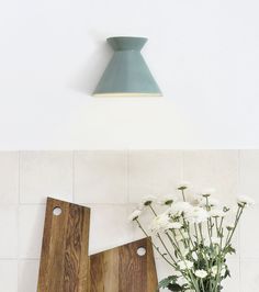 two wooden cutting boards sitting on top of a counter next to a vase with flowers