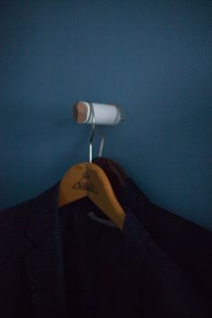 a coat hanger is hanging on a blue wall