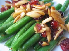 asparagus with almonds and cranberries on a white plate