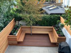 a wooden bench sitting next to a tree on top of a cement floor covered ground