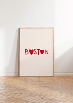 a white frame with the word boston painted on it in front of a wooden floor