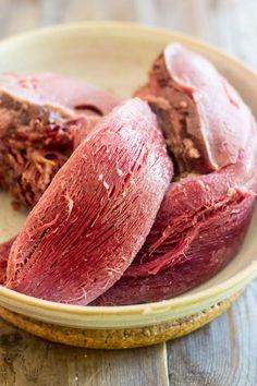 raw meat in a bowl on a wooden table