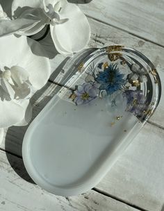 a white tray with flowers in it sitting on a table