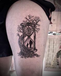 a man with a clock tattoo on his thigh next to a tree and an hour