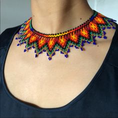 a woman wearing a multicolored beaded necklace on top of her chest,