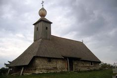 an old wooden church with a thatched roof