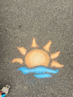 the sun is drawn on the asphalt with blue chalk and crayon pencils