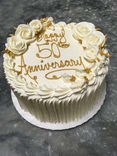 a 50th anniversary cake with white frosting and roses