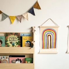 children's bookshelf with wooden shelves and colorful flags hanging on the wall