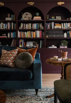 a living room filled with furniture and bookshelves covered in lots of bookcases