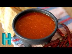 a bowl of soup and some chili on a table cloth with tortilla chips