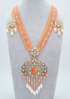 "Tyaani Kundan Double Peacock Mala Necklace Set/Peach Long Necklace Set/Indian Jewelry/Rani Haar/Bridal Necklace Set/Pakistani Jewelry,Mala Enhance your special event with the mesmerizing Peach necklace set that showcases Kundan embellishments and a mala made of hydro beads. Make sure to grab this exquisite jewelry piece before it's too late! Necklace Length: 16\" Neckline has an adjustable doori. Earring Lenght: 2\" Push-Back closure Weight : 12 gms each. Dual-tone finish on high-quality brass as a base metal. Availability: In-Stock. *Color may vary slightly due to light condition & photography. Jewelry Care:  Keep away from moisture. Allow perfumes and lotion to dry before wearing. Store in jewelry pouch. Clean only with soft lint-free cloth.  At Sparkling Trendz, we offer a wide range o Festival Necklaces With Stone Work, Traditional Orange Jewelry For Celebration, Traditional Orange Jewelry For Diwali, Orange Festive Jewelry For Celebration, Festive Orange Jewelry For Celebration, Orange Festive Celebration Jewelry, Traditional Orange Necklace For Festive Occasions, Traditional Orange Necklaces For Festivals, Orange Jewelry For Wedding And Festivals