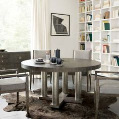 a dining room table and chairs with bookshelves in the background