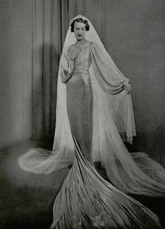 an old black and white photo of a woman in a wedding dress with a veil on her head