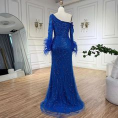 Exquisite blue mermaid gown featuring an elegant one-shoulder design, perfect for weddings, parties, and formal events in 2024. Adorned with intricate beadwork and luxurious feather details for added glamour and sophistication. Crafted from high-quality materials for a comfortable and opulent feel. Flattering mermaid silhouette beautifully enhances the feminine figure, accentuating curves. Ideal attire for women attending weddings, gala events, evening parties, and special occasions. Inspired by Fitted Blue One Shoulder Dress For Wedding, Blue One-shoulder Party Gown, Fitted Embellished One Shoulder Wedding Dress, Embellished Fitted One Shoulder Dress For Wedding, Embellished Fitted One-shoulder Wedding Dress, Blue Wedding Gown With Asymmetrical Neckline, Blue Floor-length One Shoulder Party Dress, Blue Mermaid Gown, Beaded Feathers