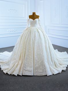 a wedding dress on display in a white room