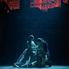 two people are dancing in the dark on stage