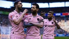 three soccer players in pink uniforms standing on a field with their hands up and looking at the camera