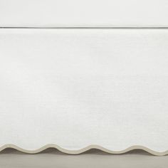 a white sheet with scalloped edges on a bed