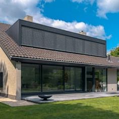 a modern house with an open patio and large windows on the side of the house