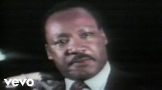 a man in a suit and tie standing next to a microphone with the words martin luther king on it