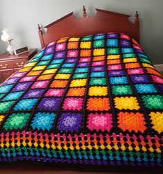 a colorful crocheted blanket on top of a bed