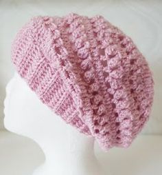 a crocheted pink hat on top of a white mannequin's head