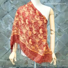 Name : Kirana Silk Scarf Fabric : 100% soft silk Size : Large (175x90 cm) Colour : Red , Gold Motif : Garden Code : SCL-DR-23Y-GD KIRANA SILK SCARF Kirana Silk Scarf is an artisan scarf (shawl) produced by La Maison D'Evolette - Elvinna Brion. it is a genuine silk fabric, displaying Batik pattern that preserve the rich cultural and multi-faceted heritage of Indonesia.  The technic we use is combining between "Batik Tulis" (Handwritten/ Handdrawn Batik) and "Batik Tjap" (Stamped Batik). Silk Silk is a natural fiber produced by silkworms. It is made from the cocoons spun by the larvae of the silk moth, known scientifically as "Bombyx mori". The silk production process begins with the cultivation of silkworms and ends with the extraction of silk threads from the cocoons. The result of silk fa Red Silk Bohemian Pashmina Shawl, Bohemian Silk Scarf With Batik Print, Silk Scarves With Traditional Patterns, Silk Scarves With Traditional Patterns And Drape, Bohemian Silk Shawl, Bohemian Batik Print Silk Scarf, Bohemian Silk Shawl With Pattern, Patterned Silk Scarf Shawl, Patterned Silk Shawl Scarf