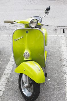 a lime green scooter parked in a parking lot with no one around it