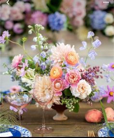 a vase filled with flowers sitting on top of a table next to two wine glasses