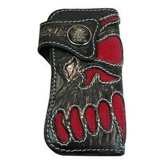 a red and black leather case with an image of a bird on it's back