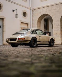 a tan porsche parked in front of a building