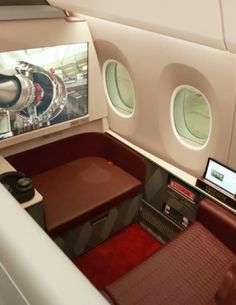 the inside of an airplane with red leather seats