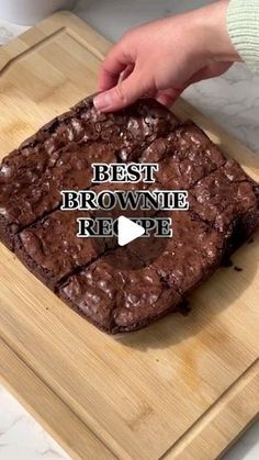 a person is cutting brownie on a wooden board with the words best brownie recipe